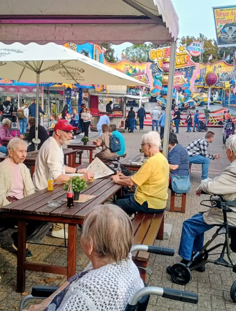 Blick über das Festgelände mit der Gruppe an den Tischen