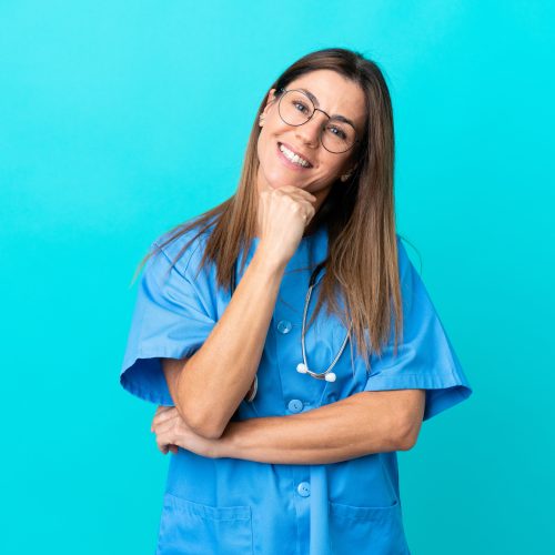 Middle age surgeon woman isolated on blue background with glasses and smiling